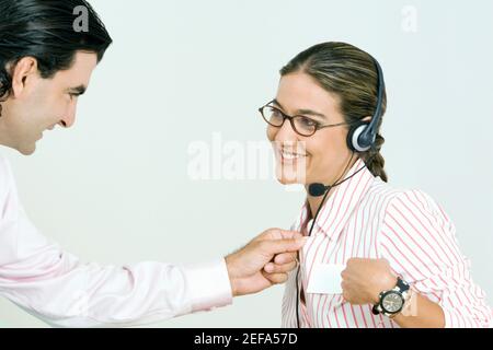 Homme d'affaires vérifiant la chemise d'une femme d'affaires Banque D'Images