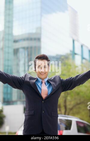 Portrait d'un homme d'affaires debout avec ses bras étirés et sourire Banque D'Images