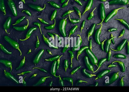 Vue de dessus de Peppers de Jalapeno vert sur fond de béton noir Banque D'Images