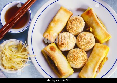 Vue à grand angle des rouleaux à ressort et du boulonnage dans une assiette avec pousses de haricots et trempette, Chine Banque D'Images