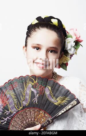 Portrait d'une fille tenant un ventilateur pliant et souriant Banque D'Images