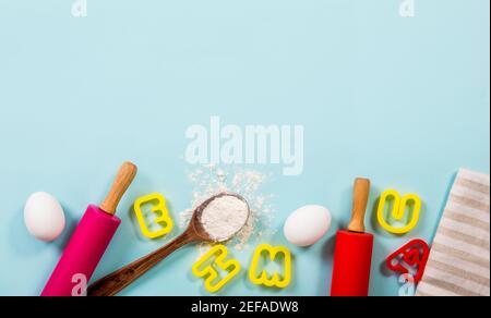 Cours de cuisine amusant pour enfants concept de bordure beaucoup d'espace pour le texte. Œufs, farine, punaises, emporte-pièces en forme de lettre sur fond bleu clair. Banque D'Images