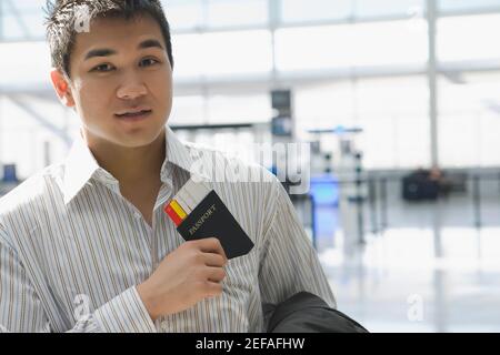 Portrait d'un jeune homme mettant un passeport avec un Billet d'avion dans sa poche Banque D'Images