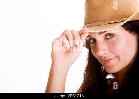 Portrait d'une jeune femme tenant le bout d'elle chapeau Banque D'Images