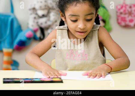 GirlÅl mains imprimer sur une feuille de papier Banque D'Images