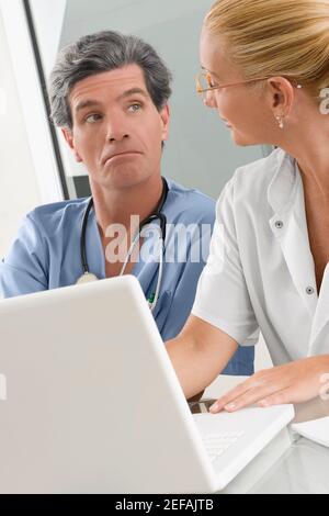 Femme médecin discutant avec un chirurgien mâle Banque D'Images