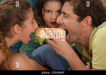 Gros plan d'une famille mangeant des hot dogs Banque D'Images