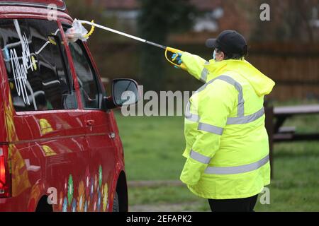 Un agent de test et de traçage dans le parking de Bramley Inn à Bramley, près de Basingstoke, Hampshire, effectue un test de coronavirus auprès d'un conducteur dans le cadre d'un programme de tests d'appoint auprès de résidents locaux, après avoir identifié un cas de la variante sud-africaine de Covid-19 dans le village. Date de la photo: Mercredi 17 février 2021. Banque D'Images