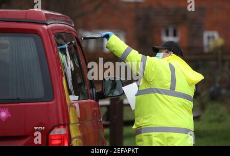 Un agent de test et de traçage dans le parking de Bramley Inn à Bramley, près de Basingstoke, Hampshire, donne un test de coronavirus à un conducteur dans le cadre d'un programme de tests de pointe avec des résidents locaux, après qu'un cas de la variante sud-africaine de Covid-19 a été identifié dans le village. Date de la photo: Mercredi 17 février 2021. Banque D'Images