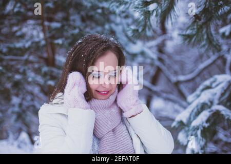 Femme regarde vers le bas et des kilomètres sous l'arbre recouvert de neige Banque D'Images