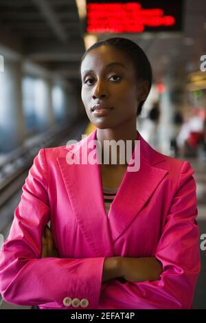 Portrait d'une femme d'affaires debout avec ses bras croisés à une station de métro Banque D'Images