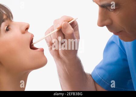 Gros plan d'un médecin de sexe masculin examinant une bouche de l'utérus mature Banque D'Images