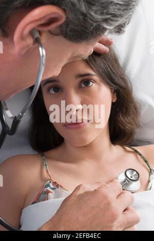 Vue en grand angle d'un médecin de sexe masculin examinant un jeune femme Banque D'Images