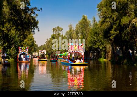 Les touristes sur les bateaux trajineras dans un canal, les jardins de Xochimilco, Mexico City, Mexique Banque D'Images