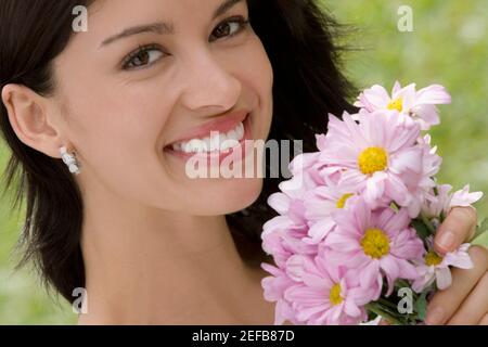 Portrait of a young woman holding a bouquet of flowers and smiling Banque D'Images