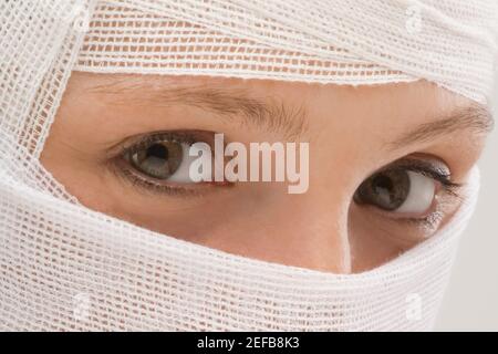 Gros plan d'un visage de jeune femme enveloppé d'un bandage Banque D'Images