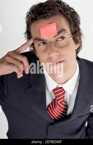 Vue en grand angle d'un homme d'affaires avec une note adhésive sur son front Banque D'Images