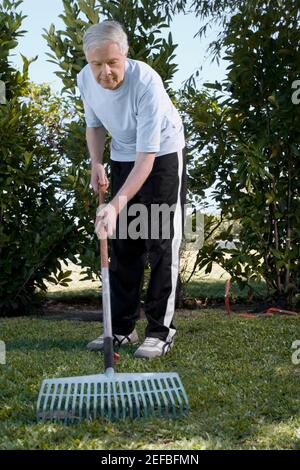 Homme de grande taille qui se fait ramer dans un jardin Banque D'Images