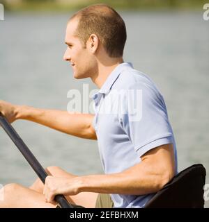 Profil d'un jeune homme en kayak dans un lac Banque D'Images