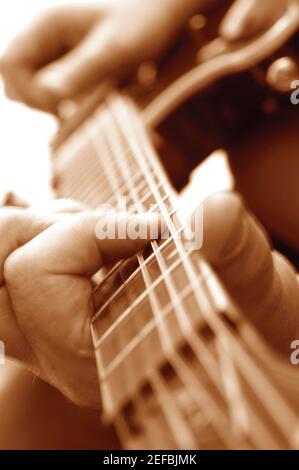 Gros plan extrême de l'homme jouant de la guitare Banque D'Images