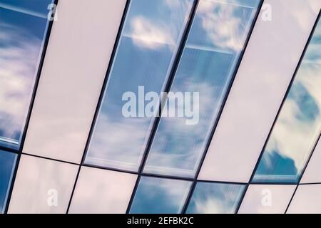 Détail de l'architecture moderne avec ciel bleu et reflets de fenêtre. Banque D'Images