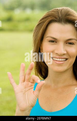 Portrait d'une femme adulte de taille moyenne montrant un signe ok Banque D'Images