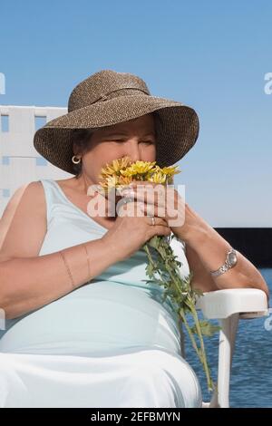 Senior woman smelling flowers Banque D'Images