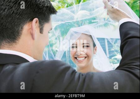Vue arrière d'un marié soulevant son voile de brideÅl Banque D'Images