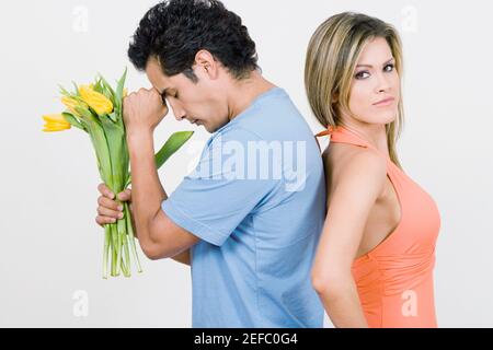 Portrait d'une jeune femme debout avec un jeune homme conservation des fleurs Banque D'Images