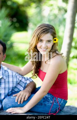 Portrait d'une jeune femme assise à côté d'un homme et sourire Banque D'Images