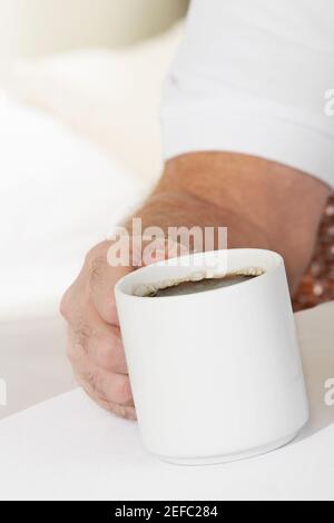 Gros plan d'une main de la personne tenant une tasse Banque D'Images