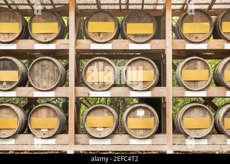 Fûts de vin sur l'étagère en bois. Fûts de vin empilés à la cave de vinification japonaise. Banque D'Images