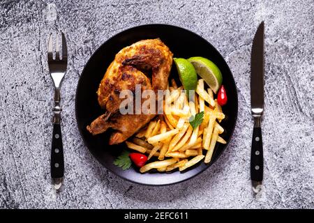 Poulet mi-rôti Piri Piri avec frites, vue de dessus Banque D'Images