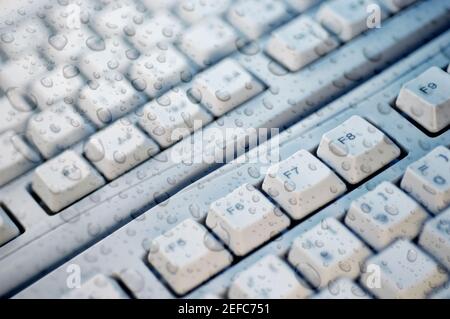 Gros plan des gouttes d'eau sur le verre au-dessus d'un clavier d'ordinateur Banque D'Images