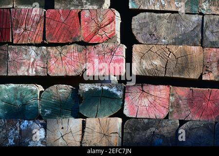 Poutres industrielles en mosaïque de bois multicolores aux couleurs vives et aux intempéries. Banque D'Images