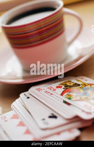 Gros plan d'une tasse de thé noir avec des cartes à jouer Banque D'Images