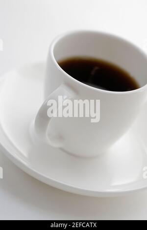 Gros plan d'une tasse de thé noir sur une soucoupe Banque D'Images