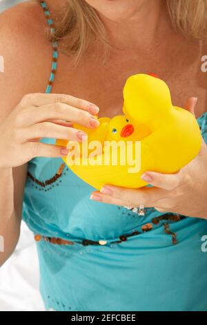 Gros plan d'une femme adulte de taille moyenne tenant des canards en caoutchouc Banque D'Images
