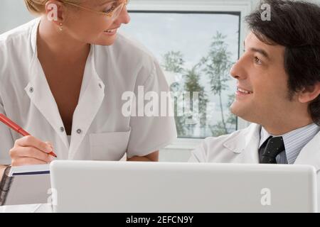 Infirmière féminine parlant à un médecin masculin Banque D'Images