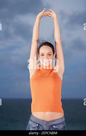 Portrait of a young woman standing with her arms Banque D'Images