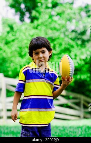 Portrait d'un garçon tenant un ballon de rugby Banque D'Images