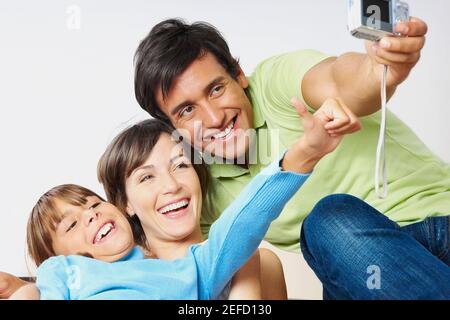 Jeune couple avec leur fille prenant une photo d'eux-mêmes Banque D'Images