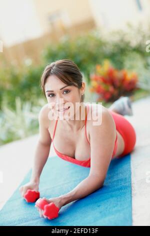 Portrait of a young woman exercising with dumbbells Banque D'Images