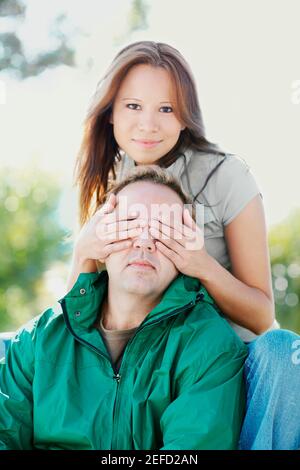 Portrait d'une jeune femme couvrant un homme adulte moyen yeux Banque D'Images