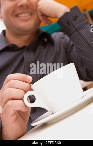 Homme adulte moyen remuant le thé Banque D'Images