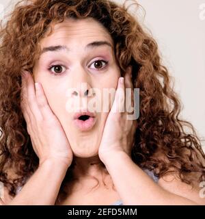 Portrait d'une jeune femme avec ses mains sur son visage Banque D'Images