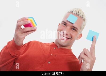 Portrait d'un jeune homme souriant avec des notes adhésives Banque D'Images