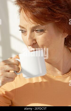 Gros plan d'une femme âgée qui boit du café Banque D'Images