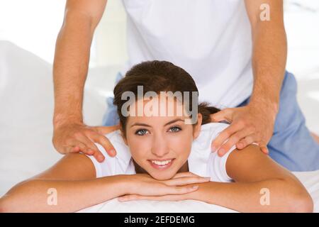 Portrait d'une jeune femme recevant un massage d'épaule Banque D'Images