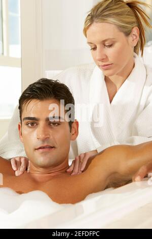 Portrait d'un jeune homme dans un bain à bulles recevant un massage Banque D'Images